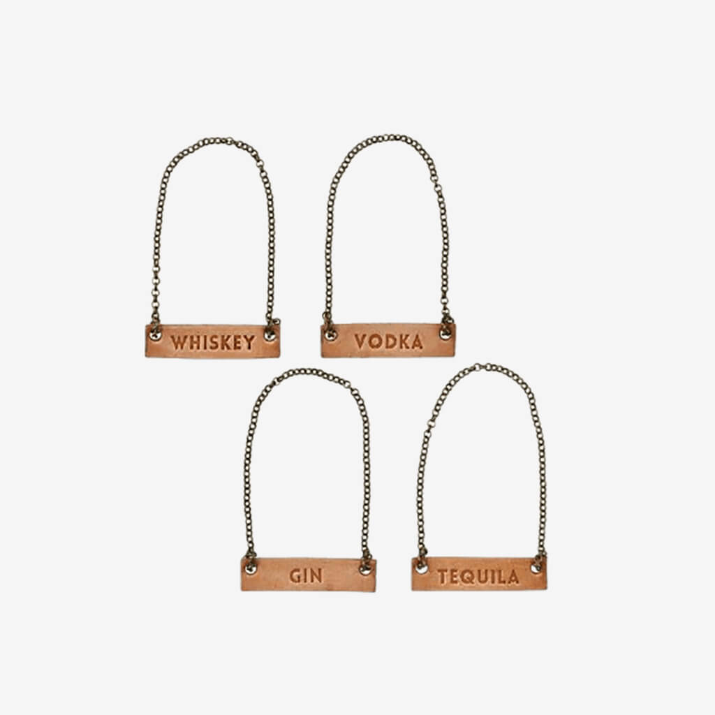 Style your bar cart and dress up a decanter with a leather decanter. Genuine leather with metal chain.     Set of 4 Tags: Vodka, Tequila, Gin, Whiskey  Say &quot;cheers&quot; with the perfect hostess gift.