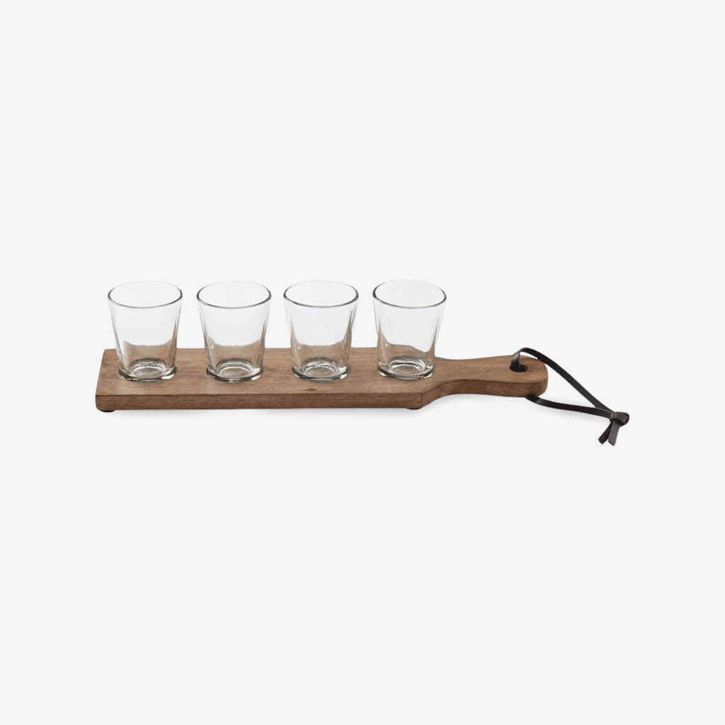 Mango wood paddle board features faux leather loop at handle and four recessed wells with burnished sentiments to hold removable shot glasses  5 piece set