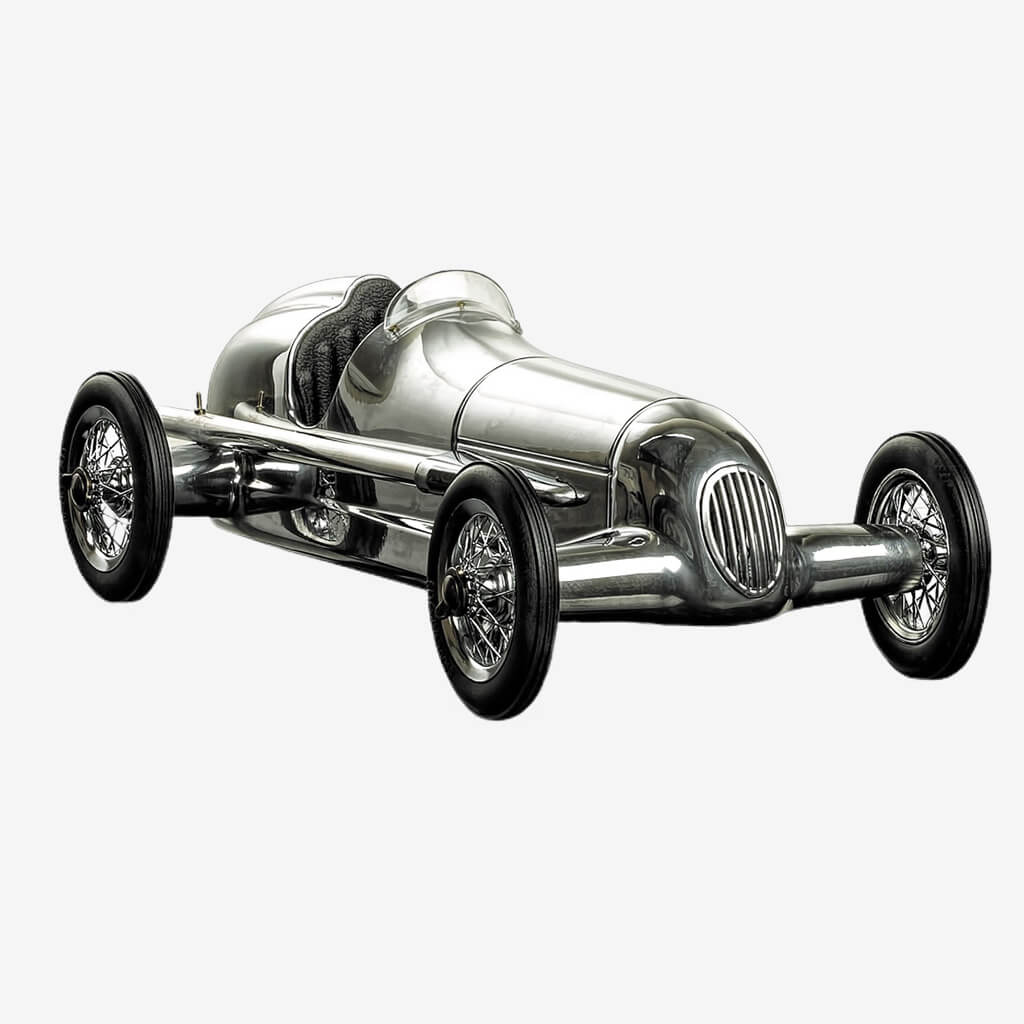 Our aluminum Indy racer is an authentic replica of a 1930s child&#39;s toy. Its original makers were the famous Dooling Brothers, who manufactured around 1000 units at the time. They were offered to aficionados of the famous Dooling spindizzies, minature motorized racecars that reached dizzying speeds. They were closely modeled on the famous Mercedes Silver Arrows of the early 1930s. Originals are now rare and highly prized by collectors.
