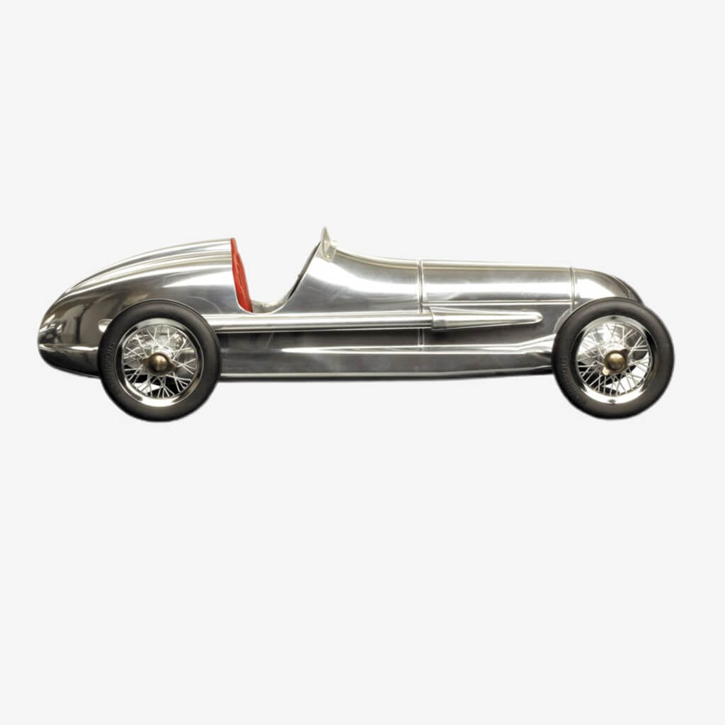 Our aluminum Indy racer is an authentic replica of a 1930s child&#39;s toy. Its original makers were the famous Dooling Brothers, who manufactured around 1000 units at the time. They were offered to aficionados of the famous Dooling spindizzies, minature motorized racecars that reached dizzying speeds. They were closely modeled on the famous Mercedes Silver Arrows of the early 1930s. Originals are now rare and highly prized by collectors.